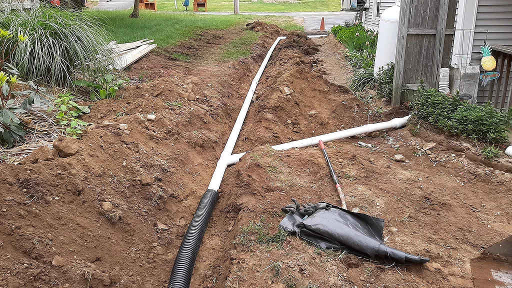 Yard drainage solutions for Central Connecticut homes, including French drains, grading, and rain gardens